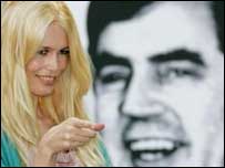 کلوديا شيفر مانکن مشهور و عضو گروه ندای جهانی برای مقابله با فقر در برابر تصوير وزير دارايی بريتانيا