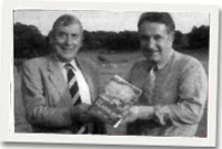 Mr Peter Loxdale yn derbny copi o'r llyfr 'Y Ganrif Gyntaf' gan Mr Neville Jones