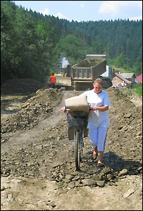 жінка йде зруйнованою дорогою. фото УНІАН