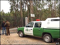 Policial fala com funcionário de Pinochet à entrada da casa de campo de Los Boldos