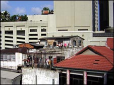 Một tòa nhà sập sệ bị bao quanh bởi nhà chọc trời