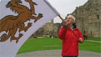 Eddie Butler waves a flag with a golden dragon on it