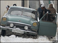 مردی ماشین خود را در برف های کابل هل می دهد