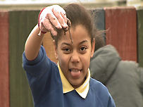 Child with a worm in the educational garden
