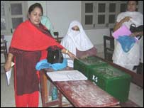 ایک پولنگ ایجنٹ بھرے ہوئے بیلٹ بکسوں کی جانب اشارہ کرتے ہوئے