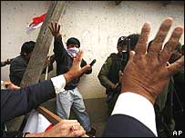 Membros da oposição ao presidente boliviano Evo Morales jogam pedras em policiais no aeroporto da cidade de Tarija