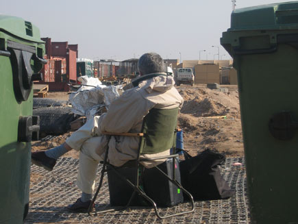Martin Bell sitting on a chair outside waiting with luggage