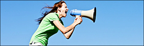 A woman shouting into a loudhailer (Image: iStock)