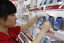 A shop assistant puts the Samsung Galaxy phone on display