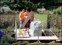 Block of stone in a garden on a platform.