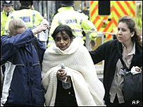 Patlamalarda yaralanan bir kadın güvenlik görevlileri tarafından uzaklaştırılırken