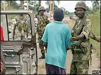 Soldados nigerianos conversam com morador