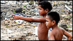 Boys survey the ruins of Salebata village on the south coast of Samoa