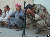 Yere çömelen siviller ve bir asker