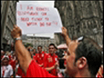 Torcedor com cartaz à procura de ingresso