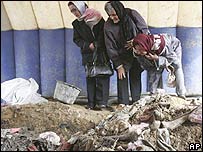 Parentes de vítimas olham nova vala comum