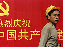 Một công nhân đi ngang qua khẩu hiệu của Đảng Cộng sản hôm 19/10