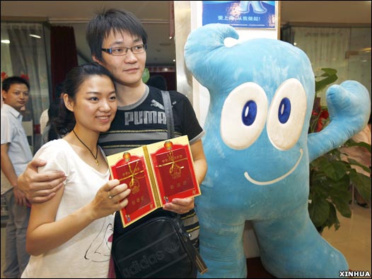 上海一对新人与世博会吉祥物“海宝”合影留念(新华社图片9/9/2009)