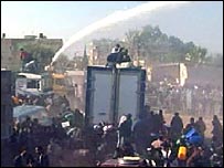 Tropas de choque egípcias usando canhões de água para conter a multidão de palestinos