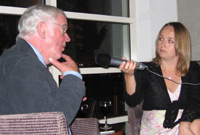 Kate Crockett yn holi John Rowlands, cadeirydd y panel beirniaid