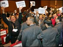 Seguranças da reunião da OMC em Hong Kong tentam conter protesto dentro do plenário