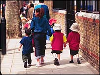 زنی با بچه هايش در خيابان قدم می زند