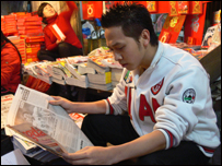 Một người hâm mộ Việt Nam đang theo dõi tin tức đội tuyển trên báo