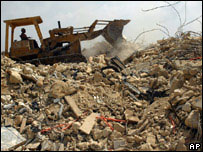 Escavadeira retira lixo em rua no Líbano