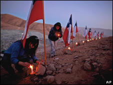 Familiares de los mineros colocan velas. 