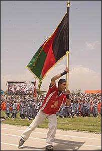 پرچم افغانستان، توسط يک دانش آموز اسکيت باز افغان در ورزشگاه شهر کابل حمل می شود