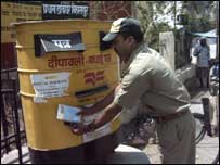 चिट्ठियाँ निकालता डाक कर्मचारी