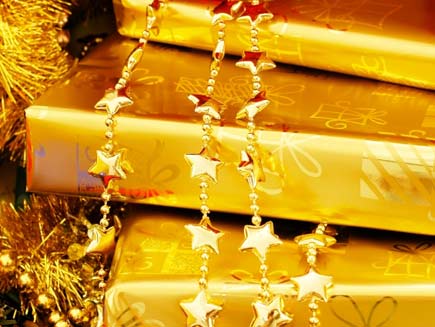 Presents wrapped in luxurious gold wrapping paper, draped with golden bead chains