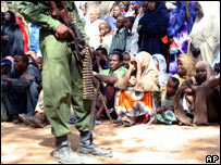 Soldado etíope em frente a grupo de pessoas em Kismayo