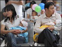 Hai ông bố bà mẹ đưa con tới khám tại bệnh viện ở Bắc Kinh