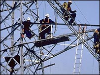 مهندسان در حال کار روی يک دکل برق