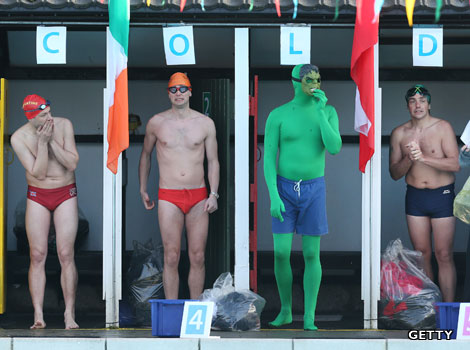 Swimmers stand in line about to take part in an outdoor swimming competition