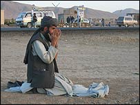 Homem reza na beira da estrada