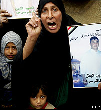 Mulher iraquiana protesta contra violência e exibe foto de mortos no conflito