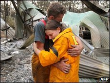 Hai tình nguyện viên cứu hoả trước một căn nhà bị cháy