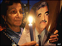 Mulher faz vigília segurando cartaz de Rafik Hariri