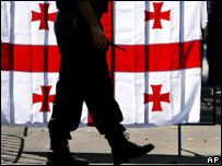 policial e bandeira da Geórgia ao fundo