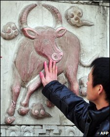 Người đàn ông và tượng con trâu tại ngôi đền ở Trung Quốc