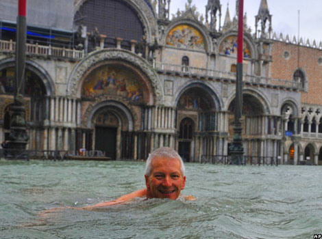 A man swims in Venice in a flooded St Mark's Square.