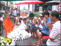 Một nhà sư cầu nguyện đáp lễ người dâng phẩm vật