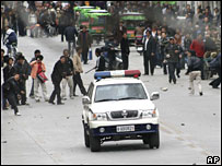 Tibetanos e veículos militares em Lhasa em 14 de março