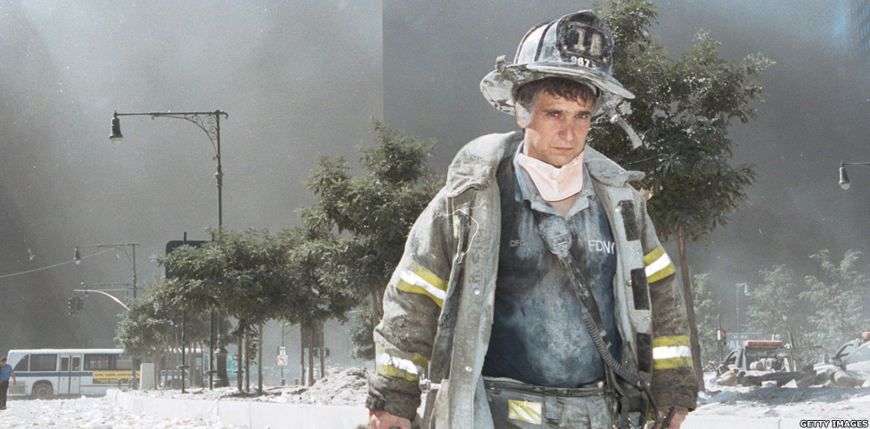 Чангу-тупроққа ботган нью-йорклик ўт ўчирувчи қулаган қўш миноралар жойини тарк этаяпти.