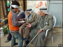 Garoto palestino entrega panfletos com propaganda de candidatos no vilarejo de Beit Furik