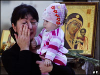 Mulher chora em visita à escola atacada em Beslan
